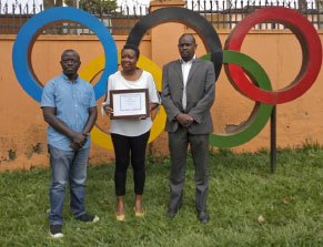 Rwese (centre) shows off her certificate as Uganda Equestrian Association president Opedun (left) and UOC assistant secretary, Nsubuga look on